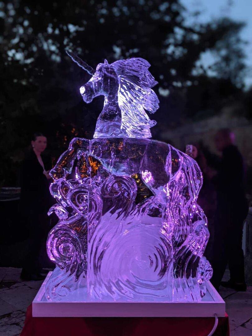 Escultura de gelo de unicórnio com logótipos de parceiros